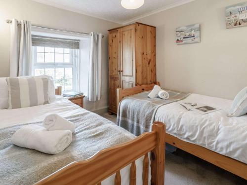 1 dormitorio con 2 camas y ventana en 4 Bed in New Quay 78589 en New Quay