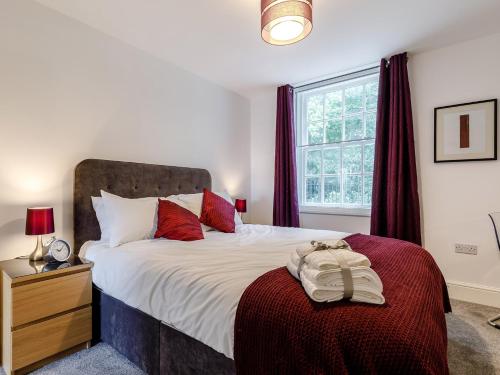 sypialnia z dużym łóżkiem z czerwonymi poduszkami w obiekcie 1 Bed in Chester 78586 w mieście Chester
