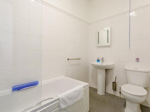Baño blanco con aseo y lavamanos en 3 Bed in Bude 78614, en Bude