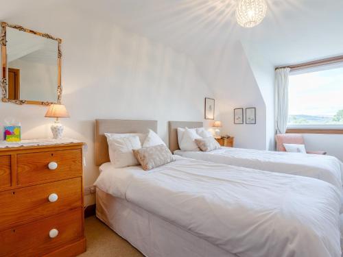 2 Bed in Aberlour 78980 في Carron: سريرين في غرفة نوم مع خزانة ومرآة