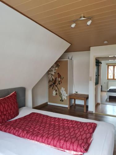 una camera da letto con un grande letto con lenzuola rosse di Ferienwohnungen Monteurzimmer zur Silbernen Kanne a Rothenburg ob der Tauber