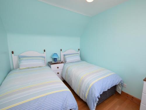 two beds sitting next to each other in a bedroom at 2 bed property in Findochty 76557 in Findochty