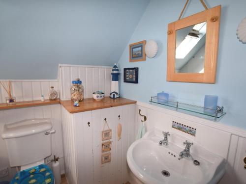 La salle de bains est pourvue d'un lavabo, de toilettes et d'un miroir. dans l'établissement 2 bed property in Findochty 76557, à Findochty