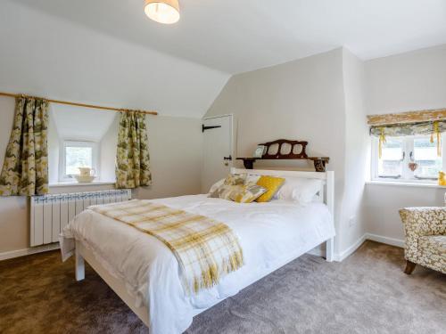 1 Schlafzimmer mit einem großen weißen Bett und 2 Fenstern in der Unterkunft 1 Bed in Bedford 79095 in Turvey