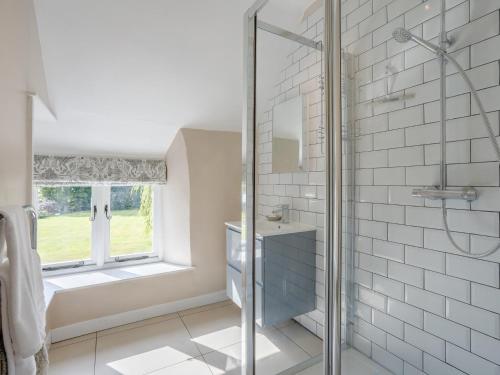 ein Bad mit einer Dusche, einem Waschbecken und einem Fenster in der Unterkunft 1 Bed in Bedford 79095 in Turvey