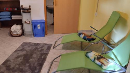 two green chairs sitting in a living room at Haus Birke in Weissensee