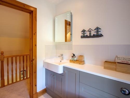 ein Bad mit einem Waschbecken und einem Spiegel in der Unterkunft 3 bed property in Blair Atholl 78841 in Trinafour