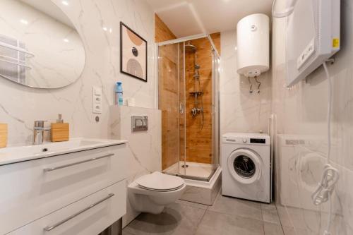 y baño blanco con aseo y ducha. en Apartament Naturalny - blisko centrum by SpaceApart, en Jelenia Góra