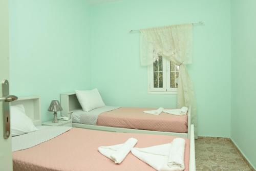1 dormitorio con 2 camas y ventana en Vasilis House, en Myrties
