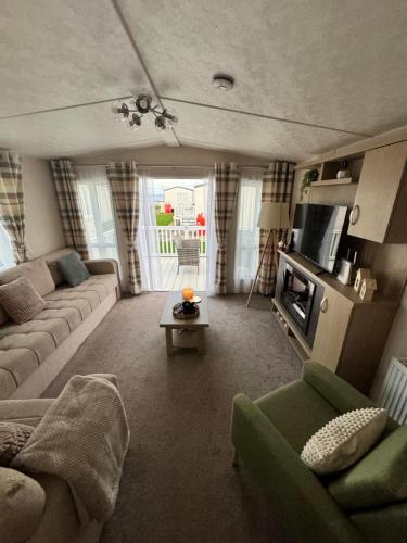 a living room with a couch and a tv at Bayview Bliss - Holiday Caravan in Newbiggin by the Sea - Northumberland in Newbiggin-by-the-Sea