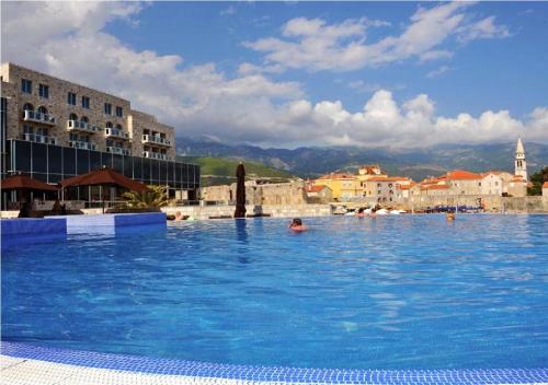 a person swimming in a large swimming pool at Avala Resort & Villas in Budva