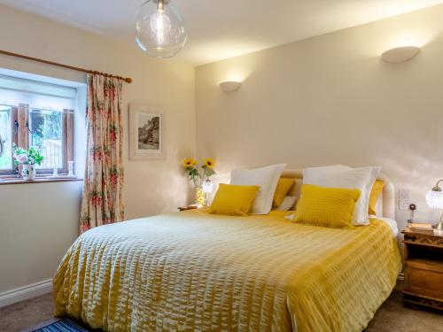 阿克斯敏斯特的住宿－2 Bed in Axminster 79208，一间卧室配有一张带黄色床单的床和一扇窗户。