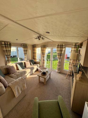 a living room with couches and a table at Bayview Bliss - Holiday Caravan in Newbiggin by the Sea - Northumberland in Newbiggin-by-the-Sea