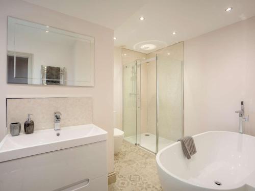 y baño blanco con lavabo y ducha. en 4 bed in Nr Druridge Bay 79370, en Hadston