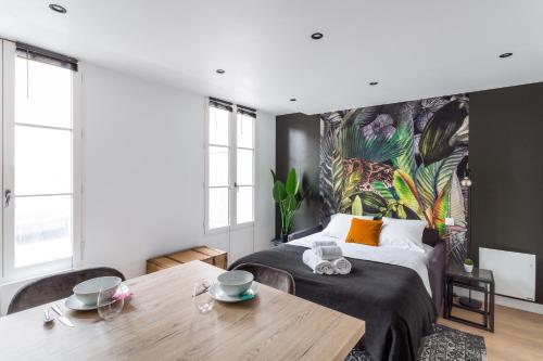 une chambre avec un grand lit et une table dans l'établissement Le Kipling - Studio de Standing à 5 min du centre Historique, à Rennes