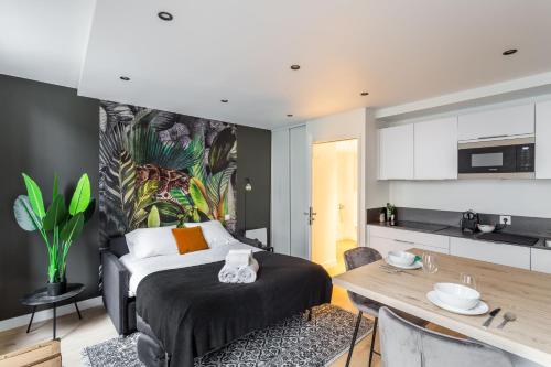 une chambre avec un lit et une table et une cuisine dans l'établissement Le Kipling - Studio de Standing à 5 min du centre Historique, à Rennes