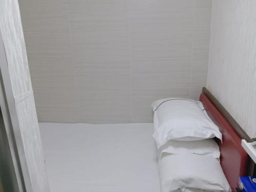 a small room with a bed with two pillows at 富都賓館 Fu Dou Guest House in Hong Kong