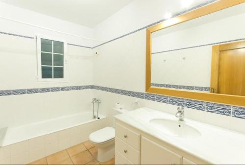 Un baño con lavabo, inodoro y espejo. en Villa Úrsula, en Santo Tomás