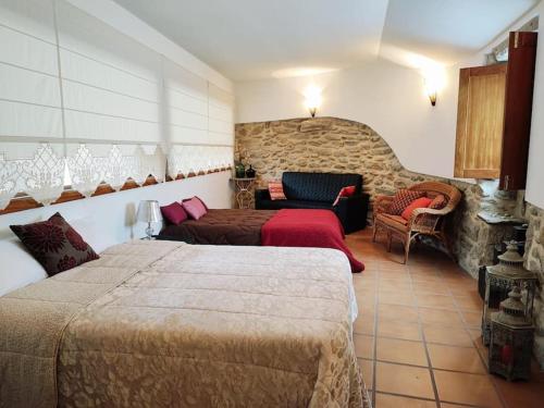 ein Hotelzimmer mit 2 Betten und einer Steinmauer in der Unterkunft Casa da Telhada Pequena in Melgaço