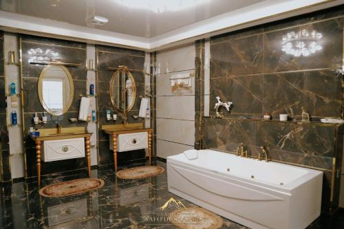 a bathroom with a tub and two mirrors at Safo Dushanbe in Dushanbe