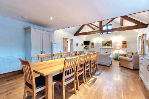 a dining room and living room with a table and chairs at Finest Retreats - The Onibury in Onibury