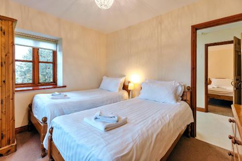 two twin beds in a room with a mirror at Finest Retreats - The Onibury in Onibury