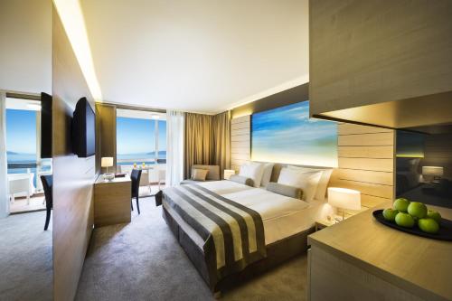 ein Hotelzimmer mit einem Bett und einem Tisch mit einer Obstschale in der Unterkunft Hotel Excelsior - Liburnia in Lovran