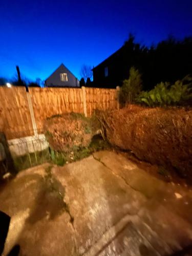 a backyard at night with a fence at 2 Bedroom Refurbished House in Curdworth