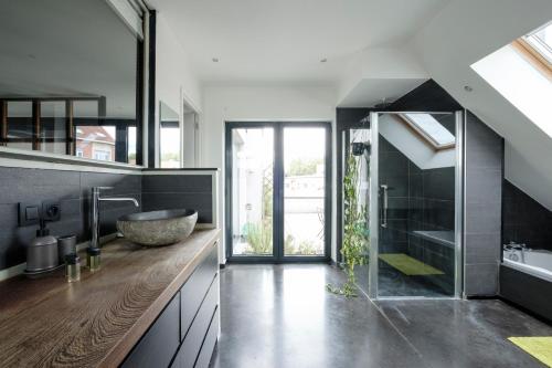 uma casa de banho com um lavatório grande e um espelho grande em Beautiful penthouse with terrace Tour & Taxis em Bruxelas
