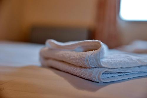 a stack of towels sitting on top of a bed at Finest Retreats - The Park in Onibury