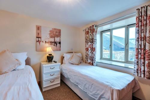 sypialnia z dwoma łóżkami i oknem w obiekcie Finest Retreats - Norton Cottage w mieście Onibury