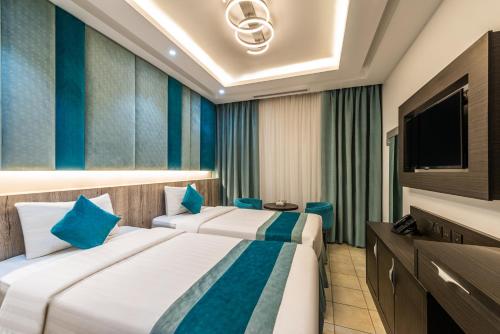 a hotel room with two beds and a television at Best Western Ajyad Makkah in Makkah