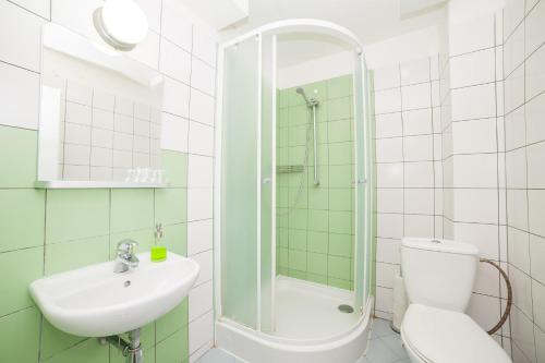 a bathroom with a shower and a toilet and a sink at Patio Hostel Dorms in Bratislava