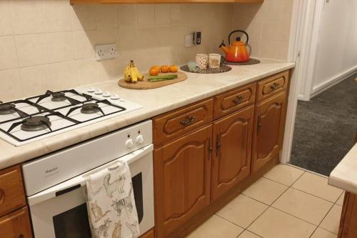 a kitchen with a stove and a plate of fruit at Welcome to Tring Cymric Home in Tring