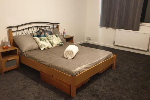 a bedroom with a wooden bed with pillows at Welcome to Tring Cymric Home in Tring