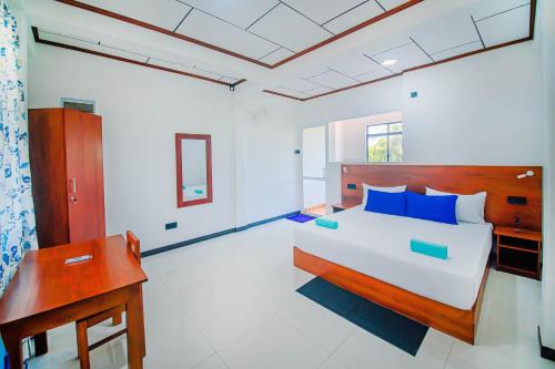 - une chambre avec un grand lit et un bureau dans l'établissement Apartments by Tyzon, à Aluthgama