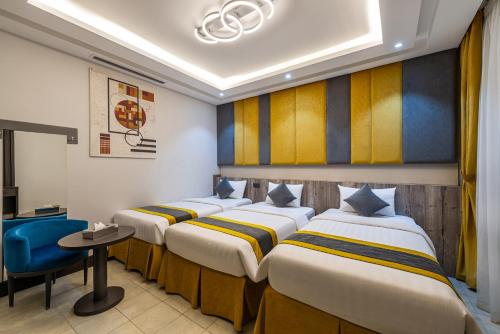 a row of beds in a hotel room at Best Western Ajyad Makkah in Makkah