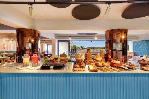 Una panadería con muchos tipos diferentes de pasteles en exposición. en Grand Mercure Goa Candolim - An Accor Hotels Brand, en Candolim