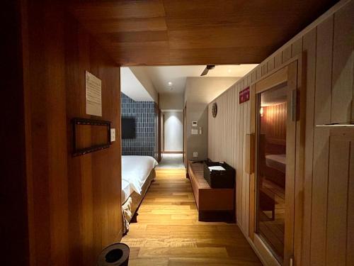a small room with a bed and a hallway at PROSTYLE TERRACE NAHA in Naha