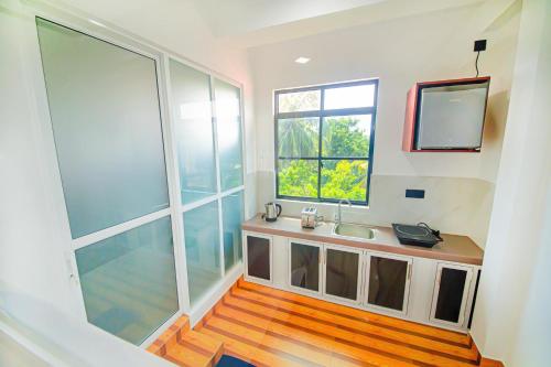 La salle de bains est pourvue d'un lavabo et d'une fenêtre. dans l'établissement Apartments by Tyzon, à Aluthgama