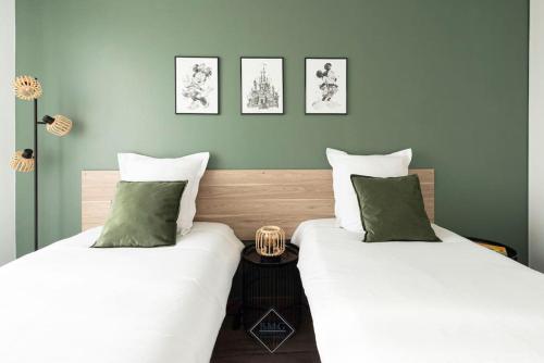 deux lits côte à côte dans une pièce dans l'établissement Harmonie appartement Disneyland Paris, à Chessy