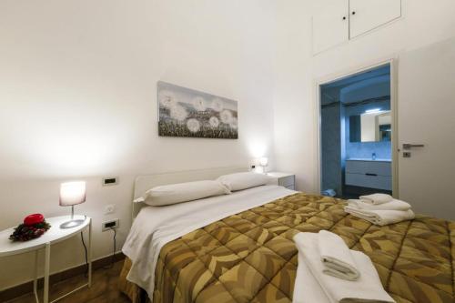 ein Schlafzimmer mit einem großen Bett und einem Tisch mit Handtüchern in der Unterkunft Casa Vacanza La Fornace Matera centro in Matera