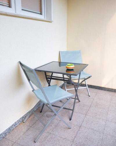 einen Tisch mit zwei Stühlen und einem Teller darauf in der Unterkunft Exclusive Home Feeling Flat in Ratingen