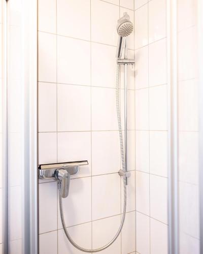 a shower in a white tiled bathroom at Exclusive Home Feeling Flat in Ratingen