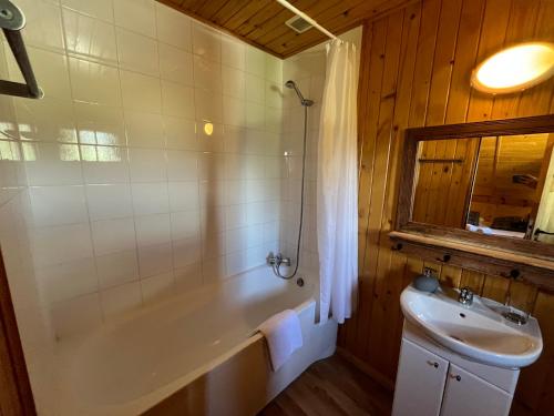 a bathroom with a bath tub and a sink at Chalet l'Aigle bleu in Uvernet