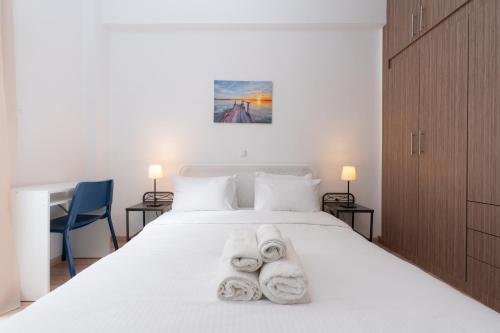 a bedroom with a white bed with towels on it at Urban Studio in Koukaki steps to Acropolis in Athens