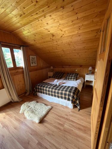 ein Schlafzimmer mit einem Bett in einer Holzhütte in der Unterkunft Chalet l'Aigle bleu in Uvernet