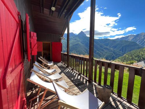a group of chairs sitting on a balcony with mountains at Chalet l'Aigle bleu in Uvernet-Fours