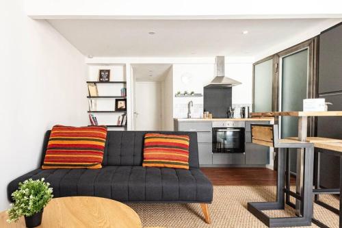 un salon avec un canapé et une cuisine dans l'établissement Appart cosy près du centre ville, à Montpellier