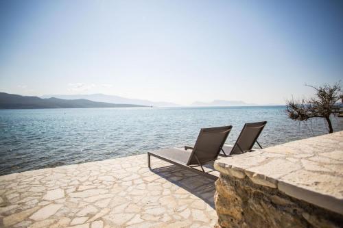 two chairs sitting next to a body of water at blue symphony suites apartments in Nikiana